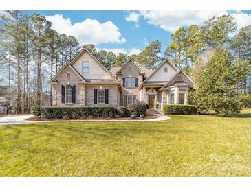 Beautiful two-story brick home with manicured lawn and mature landscaping at 7674 Bermuda Hills Ln, Denver, NC 28037