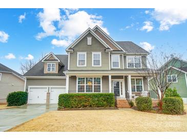 Charming two-story home boasts a manicured lawn, attached two-car garage, and inviting front porch at 1126 Snowbird Ln, Waxhaw, NC 28173