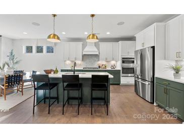 Modern kitchen features a large island, stainless steel appliances, and stylish pendant lighting at 13248 Chopin Ridge Rd, Huntersville, NC 28078