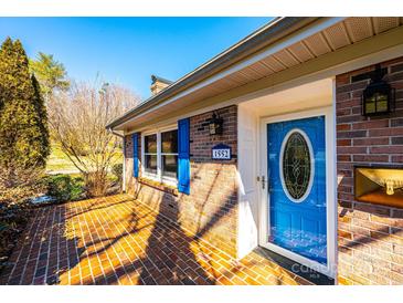 Close up of the brick home's front door, showing the blue color, sidelight, and house number at 1552 10Th Street Nw Pl, Hickory, NC 28601