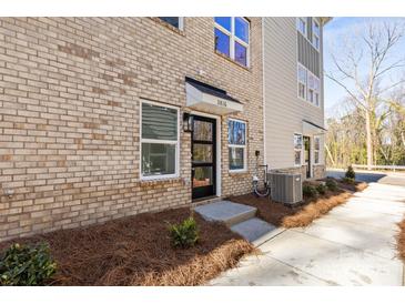 Charming brick townhome with a modern black front door and well-maintained landscaping at 3816 Odom Way, Charlotte, NC 28216