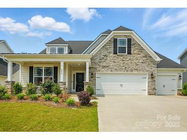 Charming home with stone accents, inviting curb appeal, and a two car garage at 6858 Hunts Mesa Dr, Fort Mill, SC 29707
