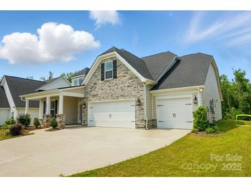 Charming home with stone accents, inviting curb appeal, and a two car garage at 6858 Hunts Mesa Dr, Fort Mill, SC 29707