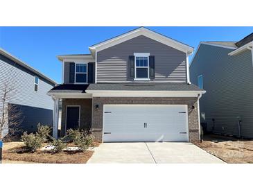 Charming two-story home with gray siding, brick accents, and a two-car garage at 1105 Harry Ct, Albemarle, NC 28001