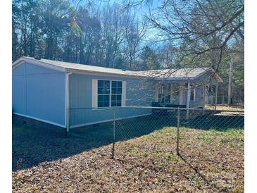 Charming single-story home featuring a light blue exterior, white trim, and a fenced yard at 13080 Philadelphia Church Rd, Oakboro, NC 28129
