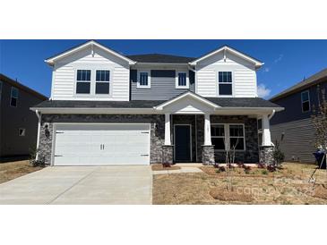 Charming two-story home with a two-car garage, stone accents, and a well-manicured front lawn at 145 Shepherds Landing Dr, Mooresville, NC 28115