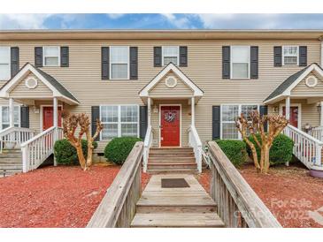 Inviting townhome featuring neutral siding, black shutters, a red front door, and attractive landscaping at 1469 Flintwood Dr, Rock Hill, SC 29732