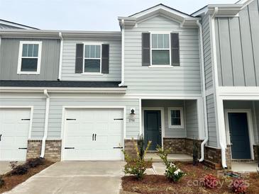 Charming townhome featuring a one-car garage, craftsman-style details, and a beautifully landscaped front yard at 1758 Braemar Village Dr, Monroe, NC 28110
