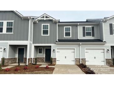 Charming two-story townhome featuring gray siding, a one-car garage, and well-maintained landscaping at 1760 Braemar Village Dr, Monroe, NC 28110