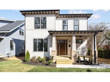 Charming two-story home with a covered front porch, landscaped yard, and modern design elements at 1828 Haines St, Charlotte, NC 28216