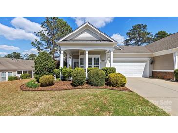 Charming home showcasing a manicured front yard with mature landscaping and inviting covered entry at 3008 Sweetleaf Dr, Fort Mill, SC 29707