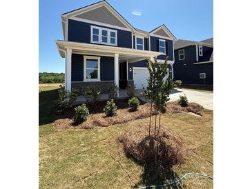 Charming two-story home with a welcoming front porch and beautifully landscaped front yard at 334 Knotty Wood Dr # 68, Monroe, NC 28110
