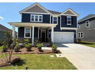Two-story home featuring a two-car garage, covered porch and nicely landscaped yard at 334 Knotty Wood Dr # 68, Monroe, NC 28110
