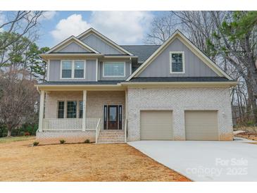 Charming two-story home featuring a brick facade, covered porch, and a two-car garage at 5125 Isaac Dr, Charlotte, NC 28216