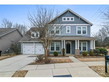 Charming two-story home with a two-car garage, inviting porch, and manicured landscaping at 11604 Bradford Park Dr, Davidson, NC 28036