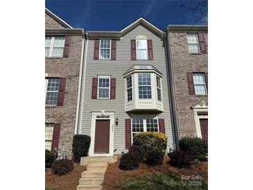 Charming townhome with gray siding, brown shutters, and a bay window showcasing a welcoming facade at 9534 Blossom Hill Dr, Huntersville, NC 28078
