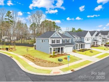 New construction two-story home featuring a manicured lawn and a welcoming front porch at 118 Golden Trl, Mooresville, NC 28115
