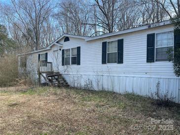 Modest single-story home with white siding and dark shutters, set against a backdrop of trees at 282 Dixon Rd, Lancaster, SC 29720