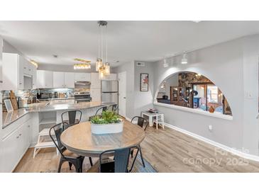 Bright kitchen featuring stainless steel appliances, granite countertops and wooden dining table at 1420 11Th Street Nw Dr # 15, Hickory, NC 28601