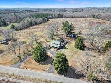 Expansive aerial view of a charming home featuring a long driveway and mature landscaping on a large lot at 1612 Forum Ln, Iron Station, NC 28080