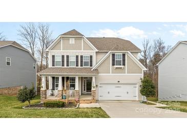 Charming two-story home features a covered front porch and a two-car garage at 3114 Woodlands Creek Dr, Monroe, NC 28110