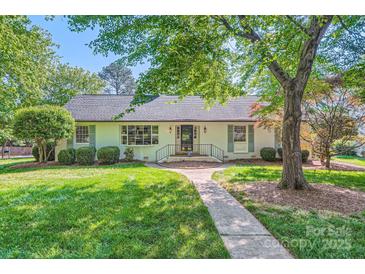 Charming white house with lush front yard, sidewalk leading to the front door at 7613 Whistlestop Rd, Charlotte, NC 28210