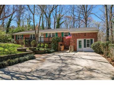 Charming single-story brick home with a lush front yard, a cozy porch, and driveway parking at 8101 Kerrybrook Cir, Charlotte, NC 28214
