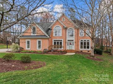 Charming brick home featuring a well-manicured lawn, large windows, and a welcoming front entrance at 9904 Duane Ct, Huntersville, NC 28078