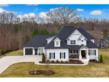 Stunning two-story home featuring a modern farmhouse design with a well-manicured lawn and black shutters at 129 Ryleigh Dan Pl, Mooresville, NC 28115