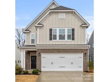 Charming two-story home featuring a brick facade and a convenient two-car garage at 3899 Center Place Dr, Harrisburg, NC 28075