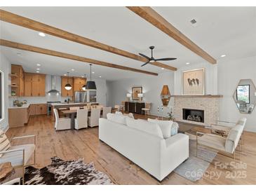 Spacious living area with a modern fireplace, hardwood floors, and an open floor plan at 5520 Chedworth Dr, Charlotte, NC 28210