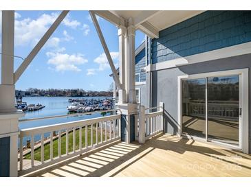 Enjoy the beautiful lake view from this home's spacious balcony with white railings and columns at 1008 Southwest Dr # 8, Davidson, NC 28036