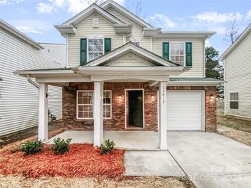 Charming two-story home featuring a brick facade, covered porch, and attached garage at 13413 Glasgow Green Ln, Charlotte, NC 28213