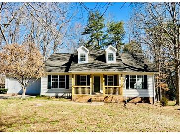 Charming home with a covered front porch and well-manicured yard, nestled among mature trees at 177 Highland Woods Ct, Denver, NC 28037