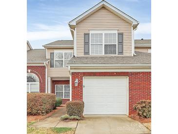 Two-story home featuring a red brick and tan siding facade with an attached two-car garage at 2313 Calabassas Ln, Matthews, NC 28105