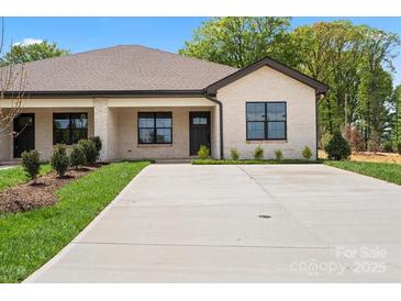 Charming single-story home with a well-manicured lawn and long concrete driveway at 2429 Ellen Ave, Charlotte, NC 28208