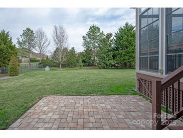 Large backyard with a brick patio and lush green lawn, perfect for outdoor living and entertaining at 841 Wandering Way Dr, Waxhaw, NC 28173