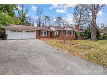 Charming brick home with a two-car garage, a long driveway, and a well-manicured front yard at 121 Ne 33Rd Ave, Hickory, NC 28601