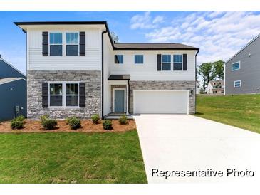 Two-story home featuring white siding, stone accents, a two-car garage, and manicured landscaping at 156 Tangle River Dr # 35, Statesville, NC 28677