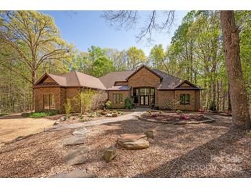 Charming brick home with a well-manicured front yard and inviting stone pathway, surrounded by lush trees at 225 Riverton Rd, Weddington, NC 28104