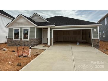 Charming single-story home features a stone facade, gray siding, and an attached two-car garage at 338 Knotty Wood Dr # 69, Monroe, NC 28110
