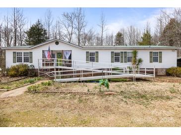 Single-story home with a long ramp, showcasing accessibility and a welcoming facade at 390 Rocky Rick Rd, Rockwell, NC 28138
