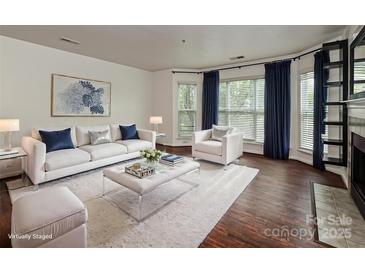 Bright living room featuring a plush white sofa, modern decor, and hardwood floors at 521 N Graham St # 2B, Charlotte, NC 28202