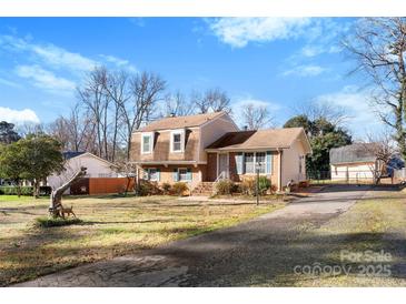 Charming two-story home featuring a well-maintained lawn, mature trees, and a private driveway at 5545 Elsinore Pl, Charlotte, NC 28227