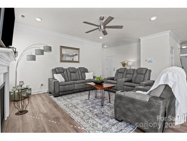 Bright living room featuring hardwood floors, modern furniture, and a stylish ceiling fan at 111 Old Field Rd, Statesville, NC 28677