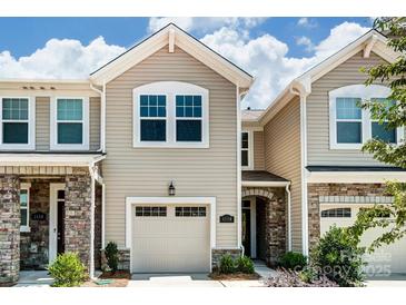 Charming townhouse with stone accents, beige siding, two-car garage and well-maintained landscaping at 12237 Gambrell Dr, Charlotte, NC 28278