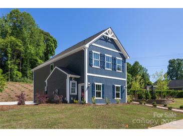 Charming two-story new construction home featuring navy siding, white trim, and a well-manicured front lawn at 1402 Richmond Dr # 1, Lowell, NC 28098