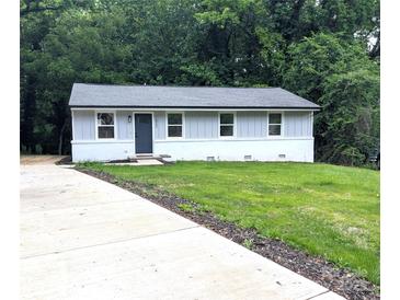 Charming single-story home with gray siding, a well-manicured lawn, and a newly paved concrete driveway at 1522 Wickham Ln, Charlotte, NC 28208