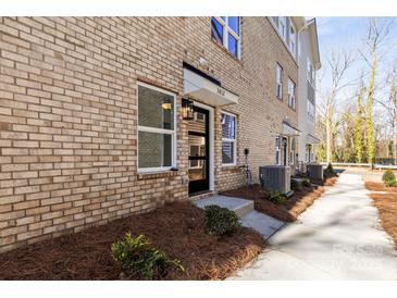 Inviting townhome exterior showcasing a brick facade, black door, and well-maintained landscaping at 3812 Odom Way, Charlotte, NC 28216