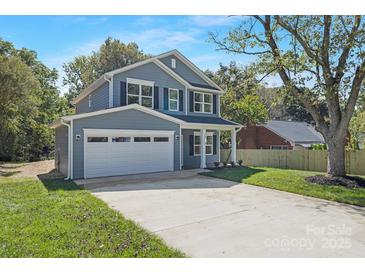 Charming two-story home featuring a two-car garage, gray siding, and a well-maintained lawn at 8465 Old Plank Rd, Charlotte, NC 28216